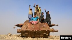 Afghan children play on the remains of a Soviet-era tank on the outskirts of Jalalabad.