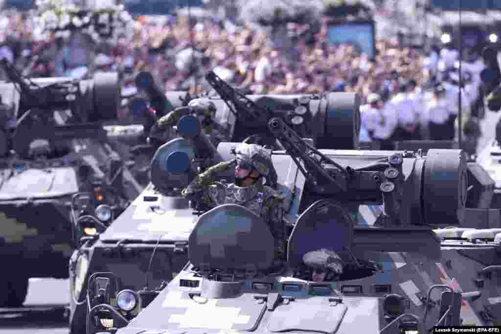 Ukrainian military vehicles drive past the crowd during the parade. 