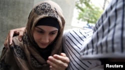 Алина Царнаева, сестра Джохара Царнаева, идёт мимо группы журналистов на заседание суда в Нью-Йорке. 30 сентября 2014 года.