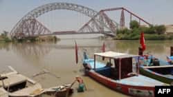 A man wades next to his boat along the Indus River near the Lansdowne Bridge in Sukkur, in Pakistan's southern Sindh Province on April 28.