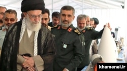 رهبر جمهوری اسلامی در کنار چند فرمانده ارشد سپاه، از جمله امیرعلی حاجی‌زاده و دورتر حسین فدوی و محمدرضا نقدی. محمد اسلامی وزیر راه در دولت روحانی و رئیس سازمان انرژی اتمی در دولت رئیسی هم در این تصویر حضور دارد.