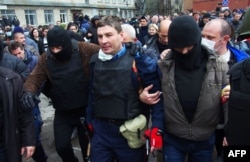Пророссийские боевики после штурма выводят из помещения начальника милиции Горловки Андрея Крищенко, не давшего установить на РУВД российский флаг, 14 апреля 2014 года