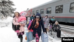 Біженці з Донбасу виходять з поїзда в Росії. Лютий 2015 року