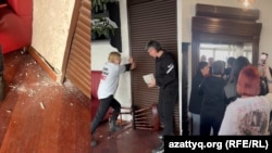 Feminita ұйымының белсенділері іс-шара өтіп жатқан залдың есігін жауып тұр.