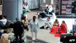 Călătorii se pregătesc să petreacă o noapte pe podea la gara Atocha, Madrid, în urma întreruperi masive de curent care a afectat întreaga peninsula Iberică și sudul Franței, pe 28 aprilie 2025.