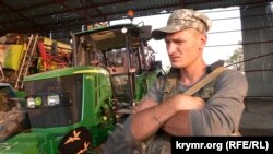 Боєць 96-го батальйону з позивним «Вовк» поруч із понівеченою сільськогосподарською технікою