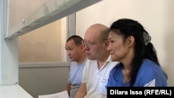 Гражданские активисты Ляззат Досмамбетова, Жанмурат Аштаев (в центре) и Кайрат Султанбек в суде по их делу. Шымкент, 13 июля 2022 года