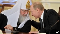 Московський патріарх Кирило слухає президента Росії Володимира Путіна. Фото від 2012 року