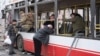 Un bărbat, plângând sprijinit de geamul unui autobuz deteriorat, în urma loviturilor rusești cu rachetă de la Sumî, pe 13 aprilie 2025