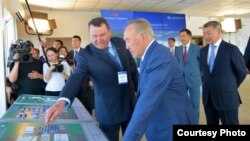 Председателя совета директоров «Азия Авто» Анатолий Балушкин показывает президенту Казахстана Нурсултану Назарбаеву строительную площадку «автопромышленного кластера» в Усть-Каменогорске. 29 июня 2016 года. Фото из официальных источников