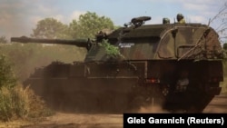 Українські військовослужбовці їдуть на німецькій САУ Panzerhaubitze 2000 на Донбасі, 12 липня 2022 року 