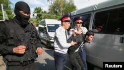 Полиция наразылық шарасына келгендердің бірін ұстап әкетіп барады. Алматы, 1 мамыр 2019 жыл.