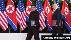 Кім Чен Ин і Дональд Трамп 12 червня у Сінгапурі із підписаним документом після зустрічі