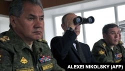 Міністр оборони Росії Сергій Шойгу, президент Росії Володимир Путін, начальник Генштабу Валерій Герасимов спостерігають за військовими навчаннями поблизу Чити в східному Сибіру. 17 липня 2013 року