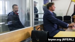 Один із «кримських дезертирів» Максим Одинцов (за склом) і його адвокат Валентин Рибін, архівне фото