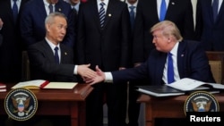 Підписи під документом поставили президент США Дональд Трамп (п) і віцепрем’єр Держради Китаю Лю Хе