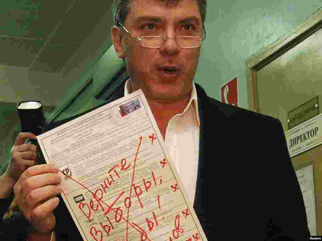 Müxalifət liderlərindən biri olan Boris Nemtsov "Seçkiləri özümüzə qaytarın" yazdığı büllütenini nümayiş etdirir.