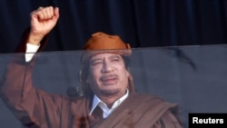 Moamer el Gadafi stoji iza staklenog zida tokom svečanosti povodom rođenja proroka Muhameda u Tripoliju, 13. februar 2011.