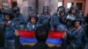 Un protestatar cu un steag armean în fața ofițerilor de poliție, în timpul unei demonstrații în sprijinul armenilor din Nagorno-Karabah, Erevan, Armenia, 20 septembrie 2023. 