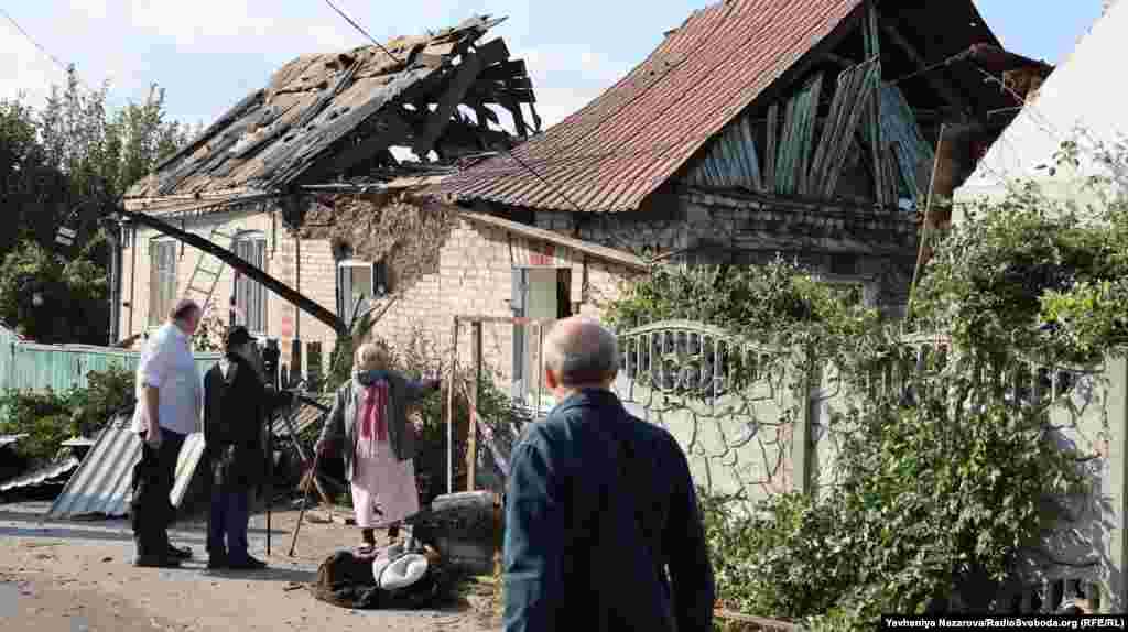 A woman stands next her house, which was destroyed by a Russian air strike. Ukraine's national police said Russia used glide bombs in three waves of attacks on Zaporizhzhya. 