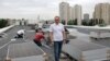 Muncitori ucraineni instalează panouri solare pe acoperișul unui spital din Kiev, în timpul unei pene de curent, pe 14 iunie 2024, după un nou atac rusesc asupra intalațiilor energetice din Ucraina.
