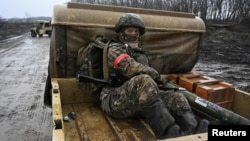 Un soldat rus călătorește în spatele unui camion în timpul antrenamentului de luptă într-un poligon de tragere, în timpul conflictului Rusia-Ucraina, în regiunea Krasnodar, Rusia, 12 decembrie 2024.