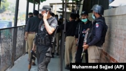 Pakistani police officers gather at a district court in Peshawar following the fatal shooting of a man accused of blasphemy on July 29.