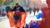 Një shitës mban në duar flamurin e Shqipërisë. Prishtinë, 28 nëntor 2020. 