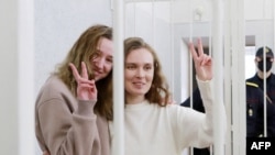 Новинарките Кациарина Андрејева (27) и Дарија Чулцова во судски кафез покажуваат знак „победа“