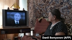 Възрастна жена от южния руски град Ставропол гледа телевизионно предаване с президента Владимир Путин, който отговаря на въпроси на народа.