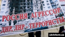 Протестувальник тримає плакат біля Запорізької міськради, архівне фото