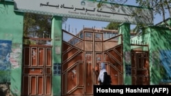 یوه ماشومه په هرات کې د خپل ښوونځي مخته تیریږي