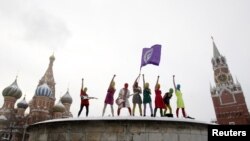 Членките на радикалната феминистичка организација „Pussy Riot“ пеат на Лубное Место(челно место), каде што порано се крунисувале руските цареви и каде што се изведувале јавни погубувања, на Црвениот Плоштад во Москва на 20 јануари 2012.