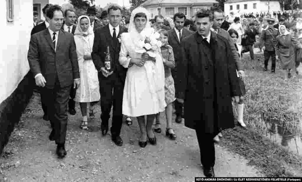 Nicolae Ceaușescu însoțește un cuplu maghiar proaspăt căsătorit, în apropiere de Brașov (1967). Deși Ceaușescu a supravegheat represiunea pe scară largă a oponenților săi politici, el a fost inițial popular în rândul românilor - mai ales după ce a luat împrumuturi străine, care asigurau aprovizionarea cu alimente a magazinelor din țară.