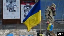 Un militar ucrainean plânge lângă un steag ucrainean la un memorial improvizat pentru soldații căzuți în Piața Independenței din Kiev. 10 noiembrie 2023. 