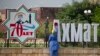 Женщина моет надпись из объемных букв "70 лет Ахмат-Хаджи Кадыров" на одной из улиц города Грозный в Чечне. Россия, 2021 год 