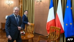 Premierul polonez Donald Tusk primindu-l la Varșovia pe președintele francez Emmanuel Macron, la 12 decembrie 2024.