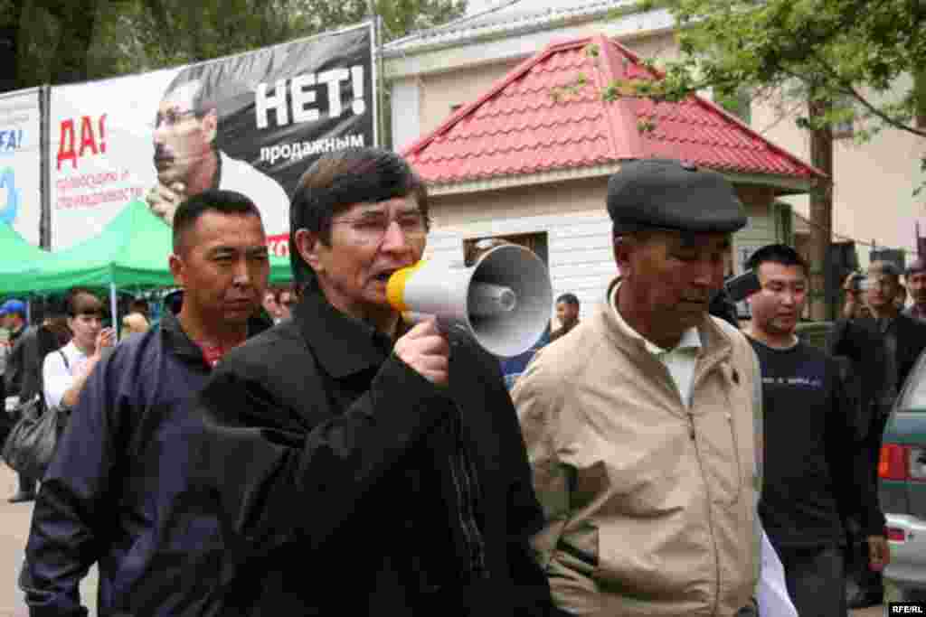 Политик Жасарал Куанышалин требует у полицейских пропустить шествие оппозиции. Алматы, 1 мая 2010 года.