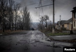 Localnici care au ales să rămână în oraș, cel puțin deocamdată, se plimbă pe o stradă pustie din Bakhmut pe 9 decembrie