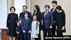 Shavkat Mirziyoev (second from left) poses for photographers with his family, including daughter Saida (center top), at a polling station after voting in Tashkent in December 2016.