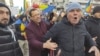 Un bărbat încearcă să liniștească un manifestant care huiduie o echipă de jurnaliști la protestul AUR, pe 12 ianuarie 2025.