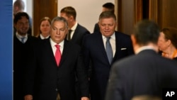 Premierul maghiar, Viktor Orban (cu cravată roșie), și cel slovac, Robert Fico (în stânga lui), sosesc la o conferință de presă la Budapesta, pe 16 ianuarie 2025.