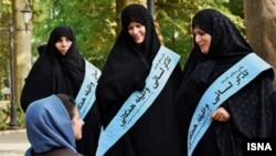 Female members of the notorious morality police known as the Guidance Patrols stop to talk to a woman in Tehran.