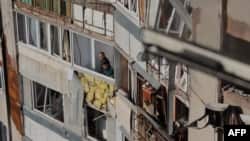 Odessada dron hücumundan sonra sakinlər sınmış pəncərələrdən bayıra baxırlar