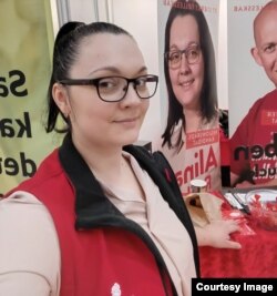 Alina, în perioada campaniei electorale, pe fundalul afișei sale de candidat.