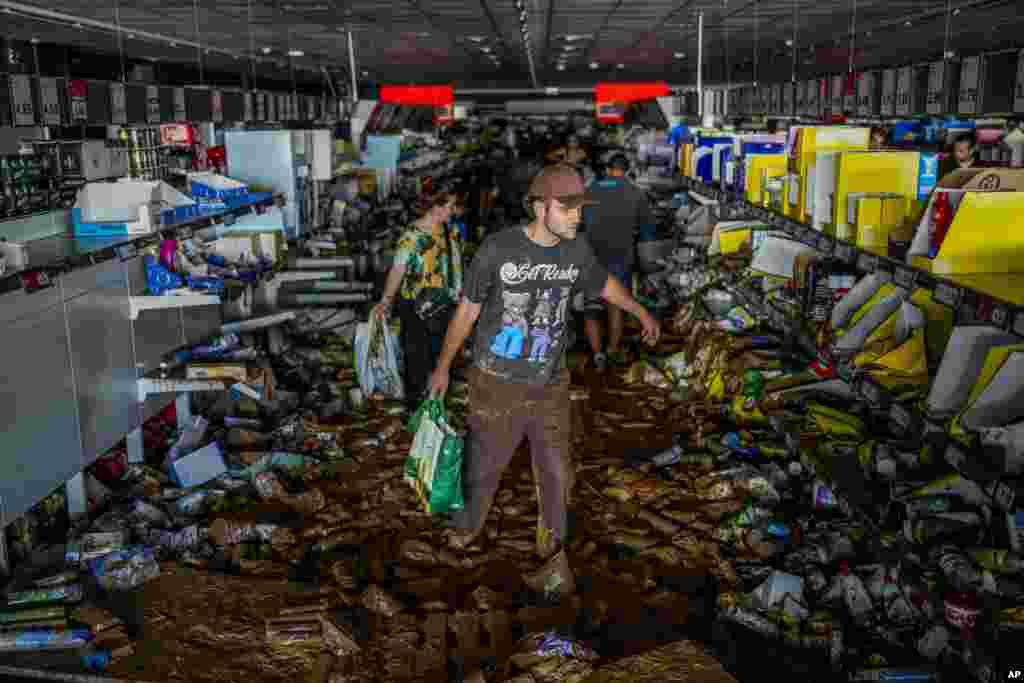 Ljudi uzimaju stvari u supermarketu pogođenom poplavama u Valensiji, 31. oktobra. Policija je tog dana uhapsila 39 ljudi koji su pljačkali u poplavljenim područjima.