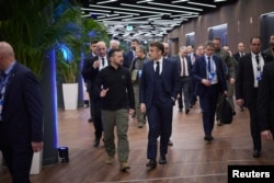 Președintele Ucrainei, Volodimir Zelenski, discută cu Emmanuel Macron, președintele Franței, în timp ce se îndreaptă spre o întâlnire în cadrul Summitului Comunității Politice Europene de la Puskas Arena, Budapesta, 7 noiembrie 2024.
