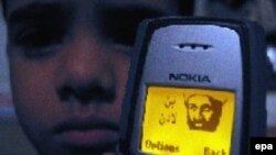 یک نوجوان پاکستانی، تصویر بن لادن را بر روی موبایلش قرار داده است.