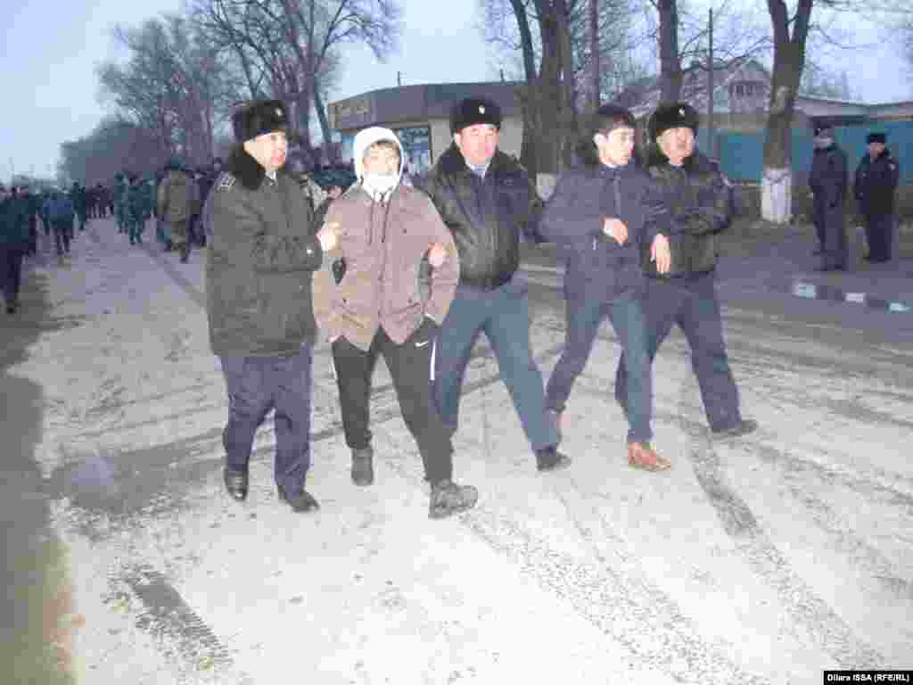 Полиция ведет задержанных в ходе событий в селе мужчин. 
