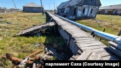 Теплотрасса, а сверху — деревянный настил. Так в Нижнеянске выглядят пешеходные дорожки